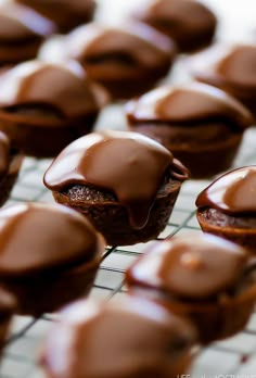 chocolate cupcakes on a cooling rack with frosting drizzled on them