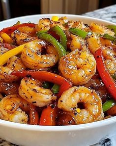 a white bowl filled with shrimp and peppers