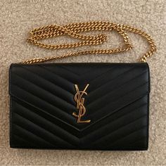 Like Brand New. Used Only A Few Times. No Damages/Scratches. Black With Gold Hardware And Gold Chain. Sticker Protector On Zipper In Place. Comes With Dust Bag, Box, And Card. Ysl Black Purse, Ysl Clutch Bag, Ysl Chain Wallet, Black Purse With Gold Chain, Chain Sticker, Black And Gold Purse, Ysl Wallet On Chain, Bags Ysl, Ysl Purse