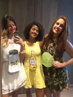 three women standing next to each other in front of a mirror taking a selfie