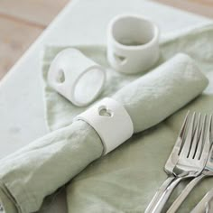 a table with silverware and napkins on it, including a fork and knife