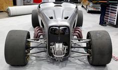 a silver race car sitting on top of a white floor