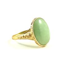 Unique light apple green jade ring Material: 14 karat yellow gold Gems: one oval cabochon Jadeite measuring approx 16.5 x 12.5 mm and weighing approx 5.25 carats  Weight: 5.1 grams Ring size: 8 1/4 Measurements: the oval top measures approx 18 x 15 mm. The band is approx 4.5 mm wide on the shoulders and tapers to approx 1.7 mm at the bottom of the shank.  Note: The ring will be accompanied by the written appraisal certificate shown in the last paragraph Green Opal Oval Ring In 14k Gold, Classic Green Oval Opal Ring, Oval Jade Rings Hallmarked, Yellow Gold Jade Cabochon Ring, Antique Gold Emerald Ring With Oval Cabochon, Antique Emerald Ring In Gold With Oval Cabochon, Green Cabochon Rings In Art Deco Style, Green Oval Heirloom Signet Ring, Heirloom Green Oval Signet Ring