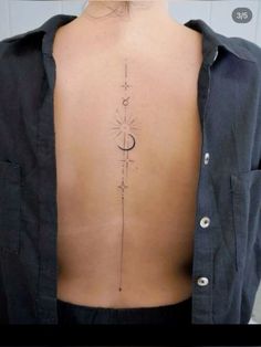 the back of a woman's neck with an arrow and moon tattoo on it