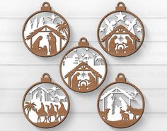 four wooden christmas ornament designs with the nativity scene in brown and white