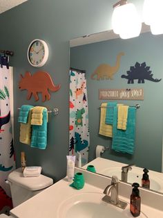 the bathroom is decorated with dinosaurs and other colorful things on the wall above the sink