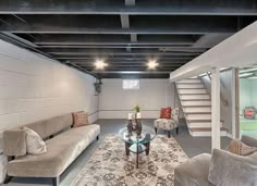 a living room filled with furniture and a stair case