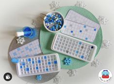 some type of game with blue and white tiles on it's tray next to a bowl of snowflakes