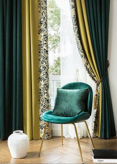 a chair sitting in front of a window with green drapes and curtains behind it