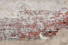 an old brick wall with peeling paint and chipping off the top, in front of it