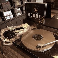 a record player with headphones on top of it in front of some other records