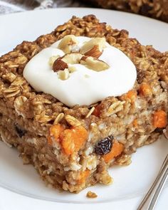 a white plate topped with oatmeal and raisins next to a fork