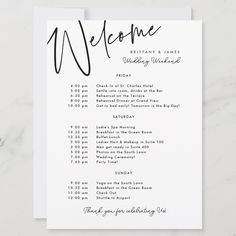 a white wedding welcome card with black ink on it and the words welcome written in cursive writing