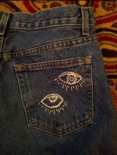 the back pocket of a pair of jeans with an eye drawn on it