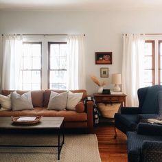 a living room with two couches and a coffee table in front of the window