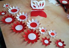 paper flowers are cut out and placed on a wooden table with scissors in the background