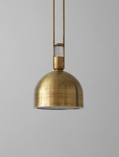 a large brass pendant light hanging from a ceiling