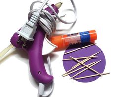 a purple hair dryer sitting next to some knitting needles and an orange pinwheel