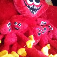 several red stuffed animals with big eyes and mouths