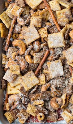 a baking pan filled with homemade cheetos and pretzel crackers covered in powdered sugar