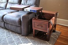 a living room with a gray couch and wooden end tables on the carpeted floor