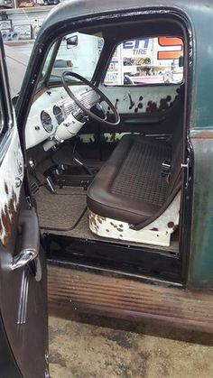 an old truck with the door open and seat up