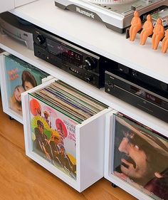 a record player sitting on top of a white shelf filled with cds and vinyl records