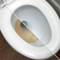 a white toilet sitting on top of a wooden floor