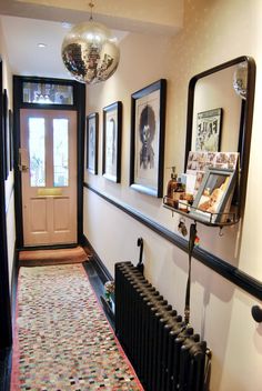 a hallway with pictures on the wall and a radiator in front of it