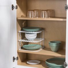 an open cabinet with dishes and glasses in it