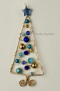 a wire christmas tree ornament with blue and gold ornaments on it's side