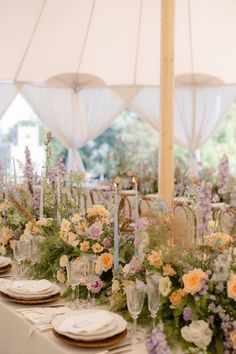 the table is set with flowers, candles and place settings for an elegant wedding reception