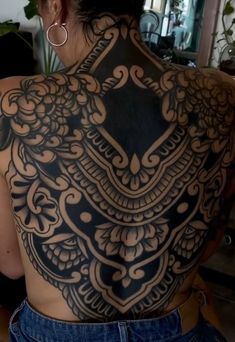 the back of a woman's body with tattoos on it