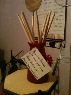 there is a vase with sticks in it and a note attached to the top one