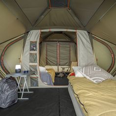 the inside of a tent with two beds in it