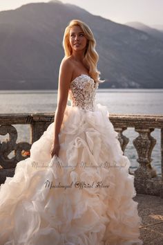 a woman in a wedding dress standing by the water