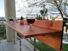 a glass of wine sitting on top of a wooden table next to a potted plant