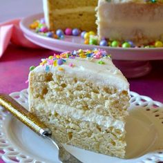 a piece of cake with white frosting and sprinkles on a plate