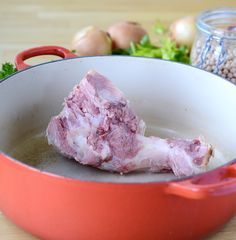 raw meat is being cooked in a red pot