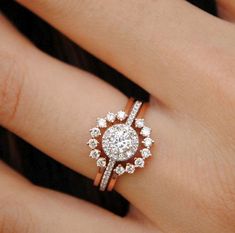 a woman's hand with a diamond ring on top of her finger and an engagement band