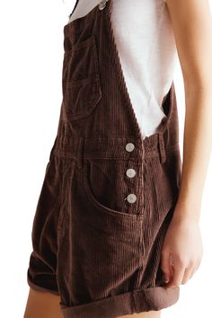 Ziggy Overalls Wash: Barnwood Dark brown curduroy short overalls. Bib-and-brace design with adjustable straps Front and side pockets Rolled hems Side tab button closure Relaxed fit Rise: 11.75" | Inseam: 5.5" (taken from size Small) 100% Cotton | Model is wearing a size Small Cottage Core Overalls Outfit, Ziggy Overalls, Overall Shorts Outfit, Oversized Overalls, Style Uniform, Baggy Shirts, Corduroy Dungarees, Outfits Baggy, Overalls Outfit