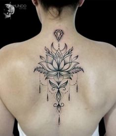 a woman's back with a lotus tattoo on it