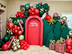 christmas decorations are displayed in front of a red door and green trees with candy canes