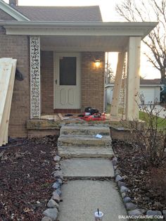 a house that is being remodeled with some wood on the front porch and steps leading up to it