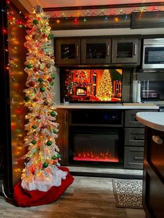 a decorated christmas tree in front of a fireplace with lights on it and an oven