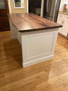 a kitchen island made out of wood and white cabinets