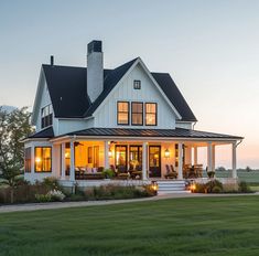 a large white house sitting on top of a lush green field