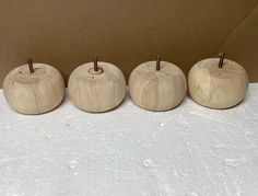 four wooden apples are lined up in a row