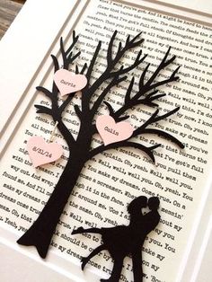 the silhouette of a man and woman kissing under a tree with paper hearts attached to it