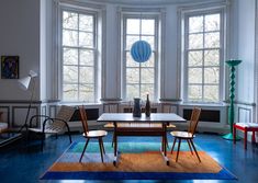 a dining room with blue floors and large windows